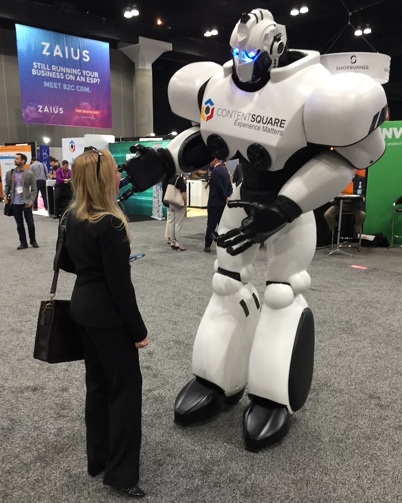 Paige Macdonald standing beside a technology robot during her years working in the tech industry